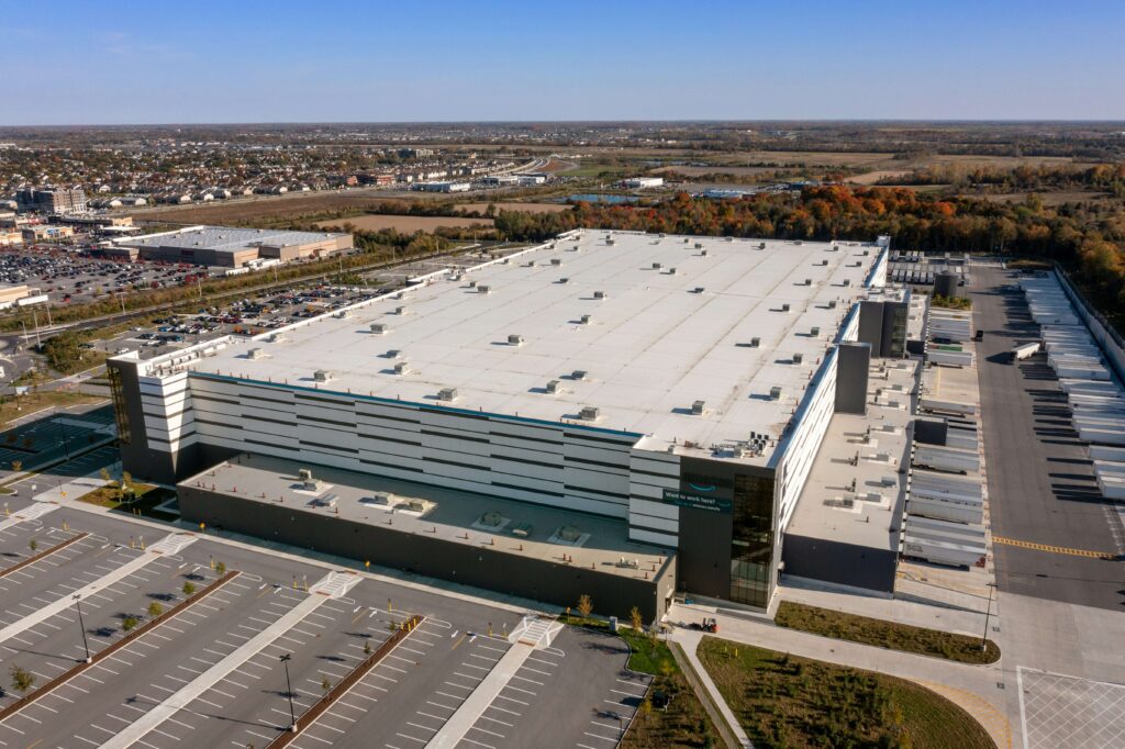 Aerial drone view of a large warehouse distribution center and surrounding industrial park