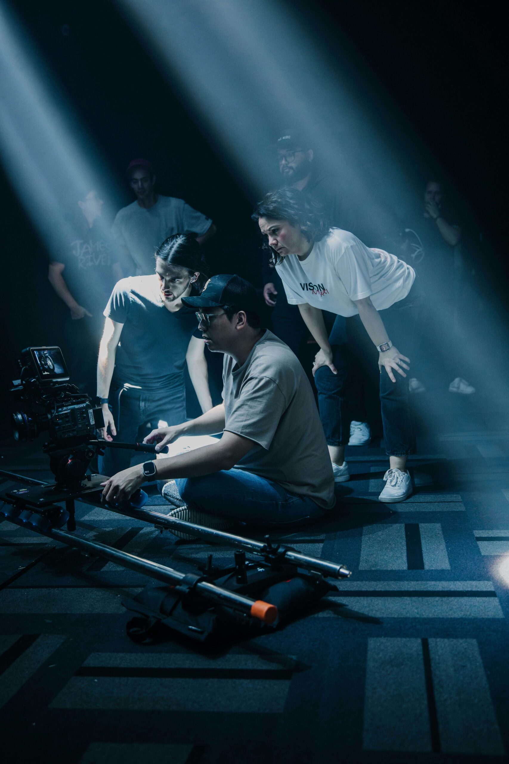 Bilingual video crew filming a safety training interview inside a warehouse.
