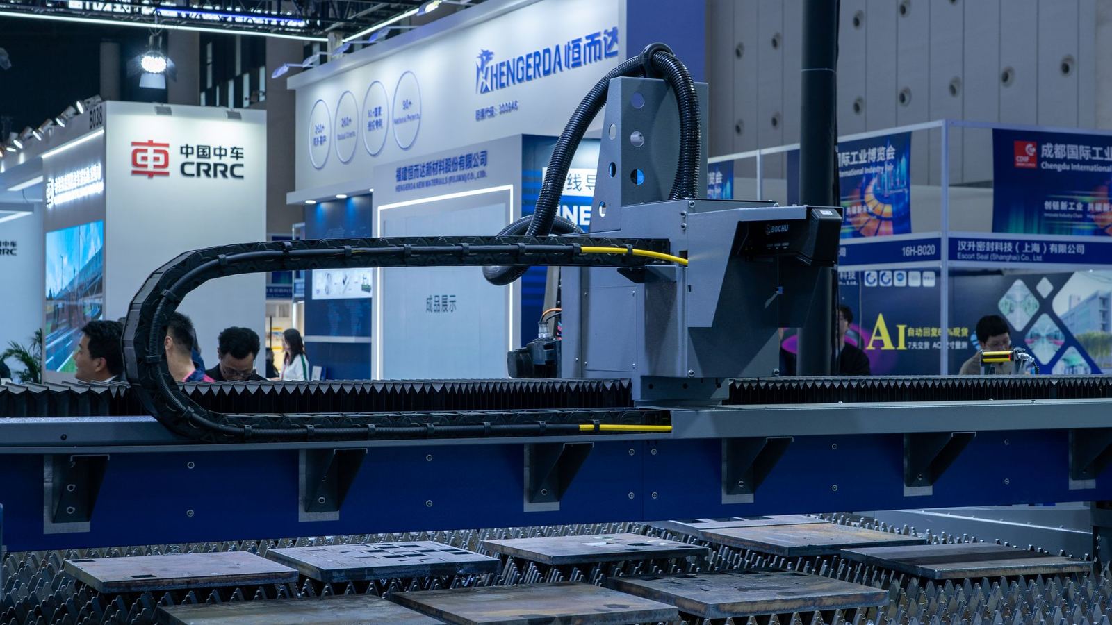 Industrial cutting machine on display at a manufacturing trade show booth