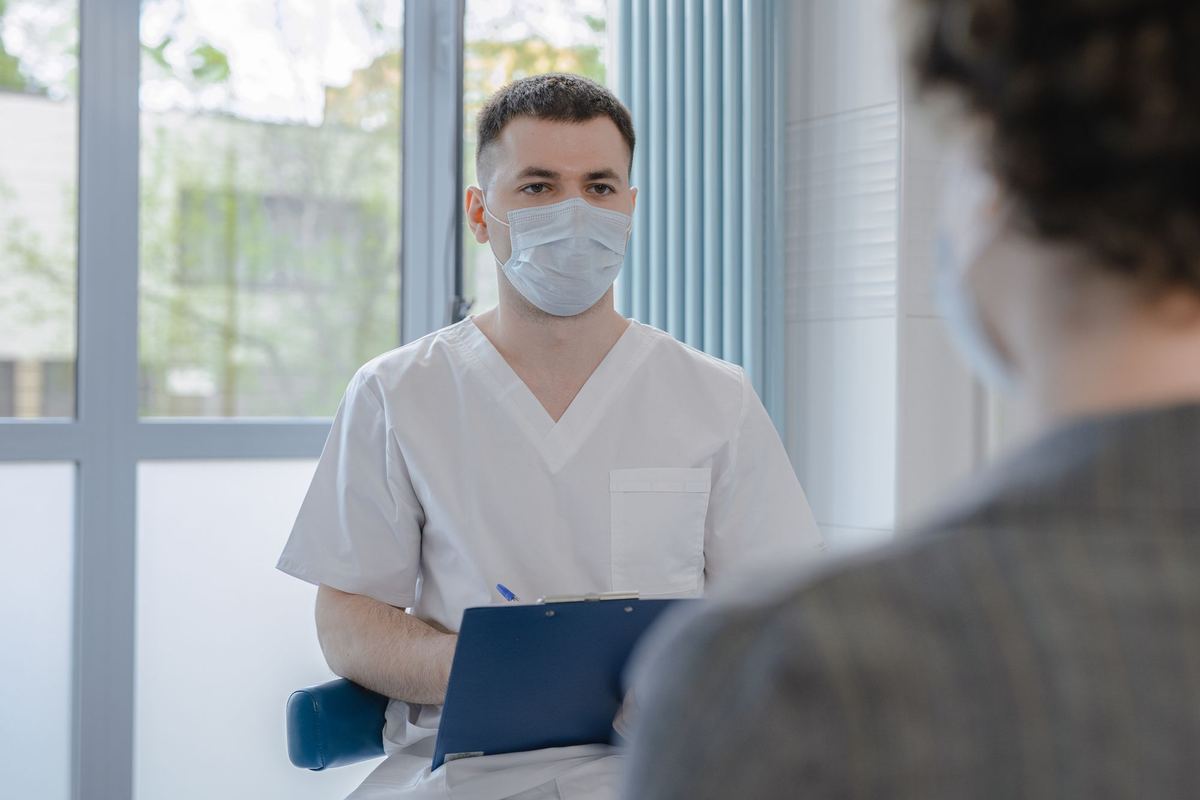 Healthcare staff member explaining a consent form to a patient before filming