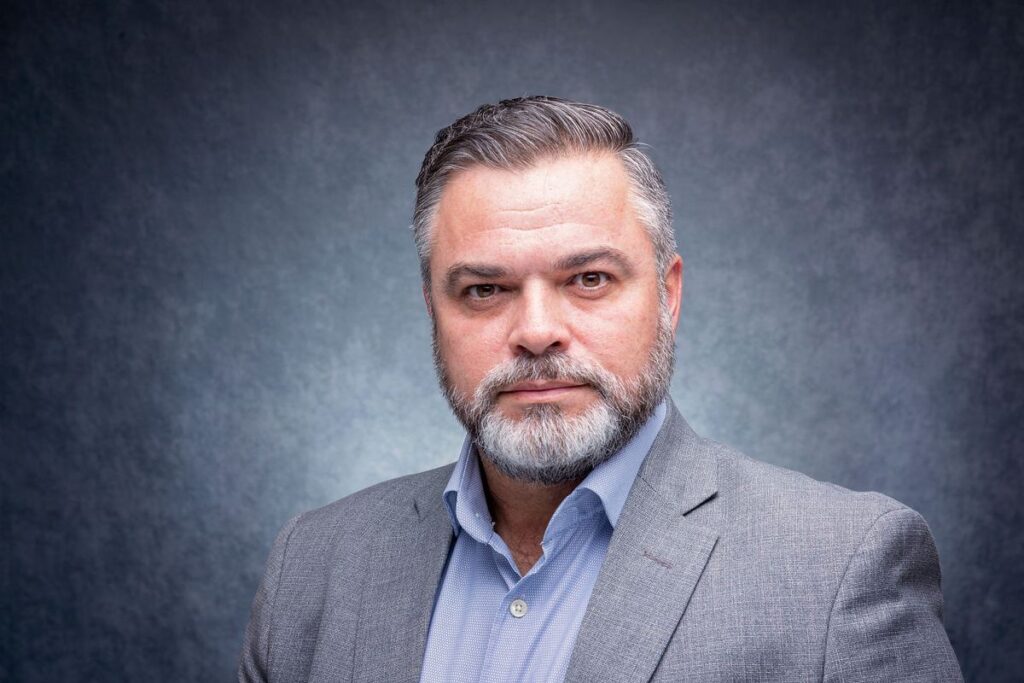 Employee headshot photographed with consistent background and lighting