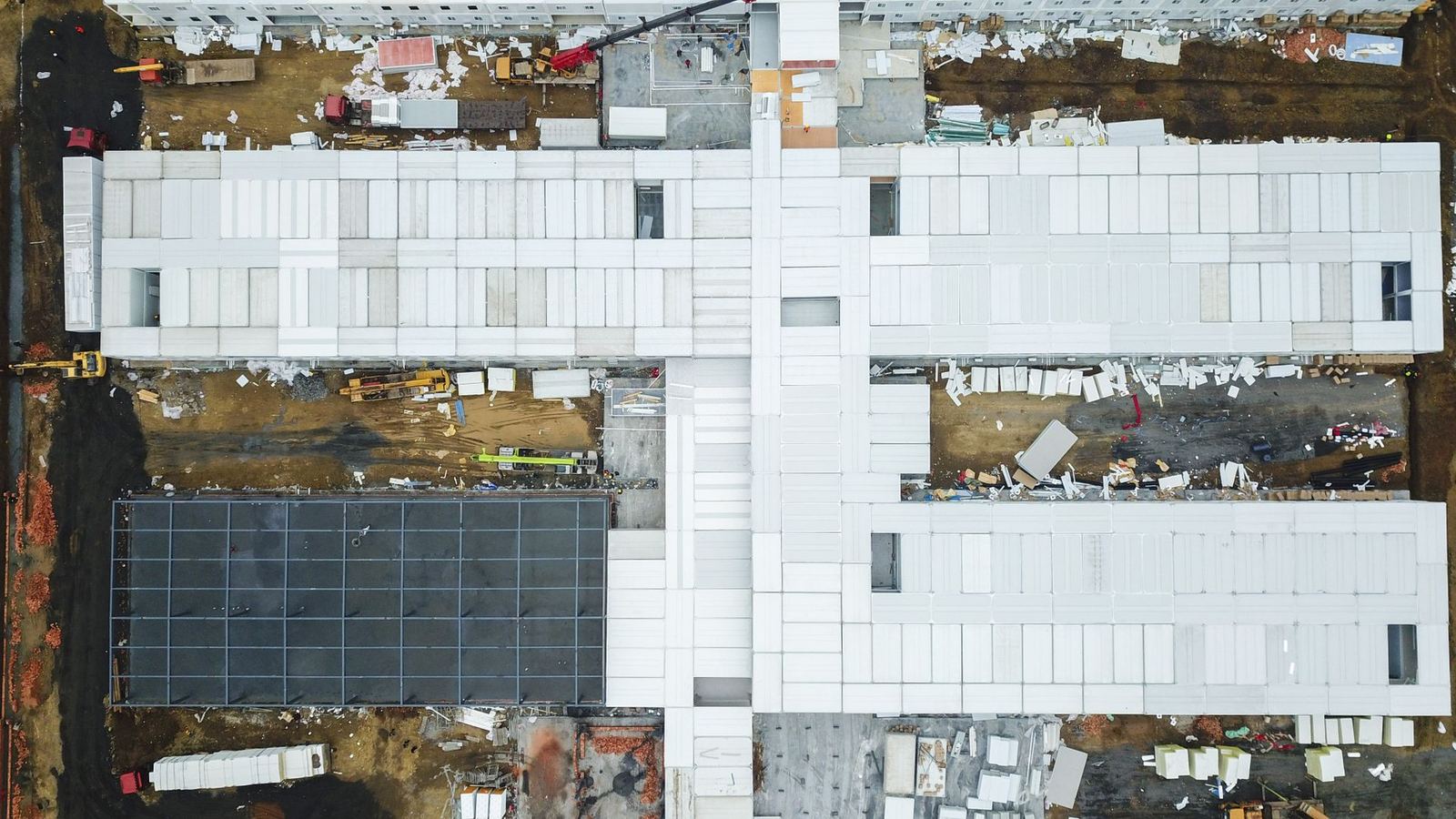 Aerial drone view of a large building under construction, seen from directly above